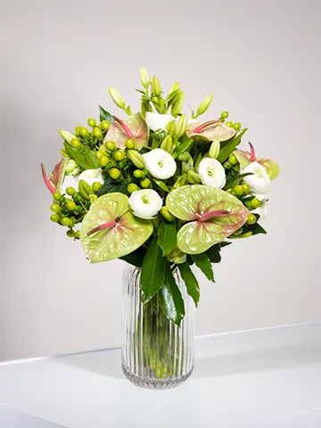 Bouquet di anthurium pistache ranuncoli bianchi e bacche verdi